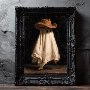Pu&ograve; includere: Un dipinto a olio incorniciato raffigurante una figura drappeggiata in un lenzuolo bianco che indossa un cappello da cowboy marrone. La figura ha due fori scuri per gli occhi e si staglia su uno sfondo scuro. L'opera &egrave; in una cornice nera opaca.
