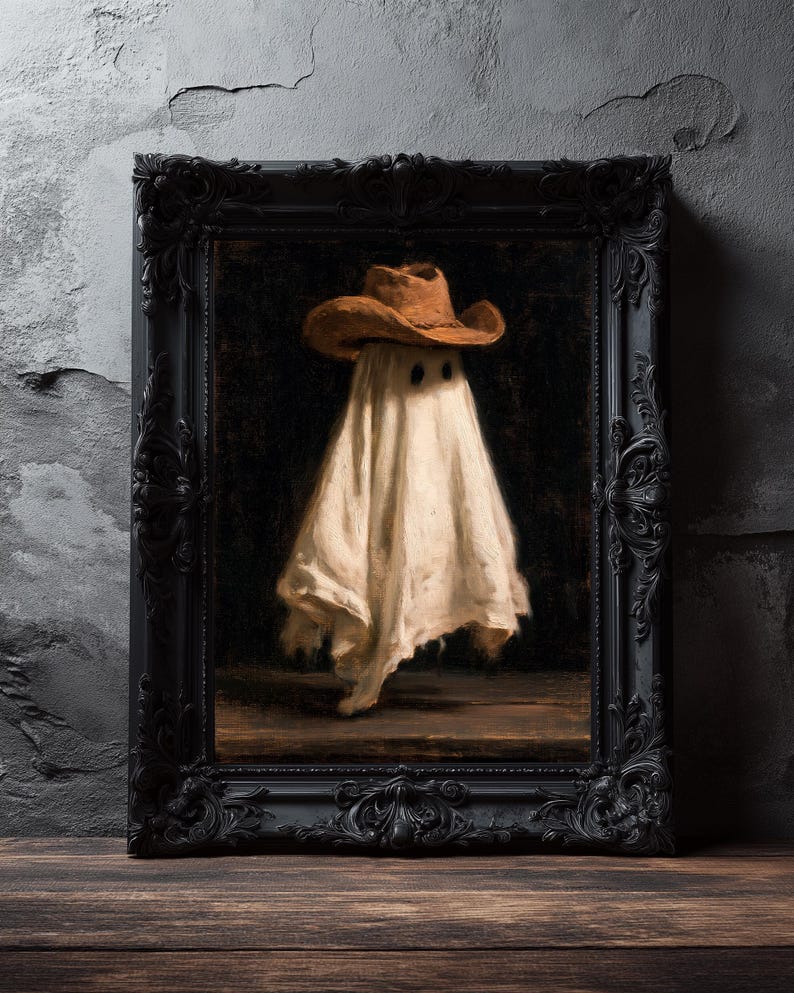 Pu&ograve; includere: Un dipinto a olio incorniciato raffigurante una figura drappeggiata in un lenzuolo bianco che indossa un cappello da cowboy marrone. La figura ha due fori scuri per gli occhi e si staglia su uno sfondo scuro. L'opera &egrave; in una cornice nera opaca.