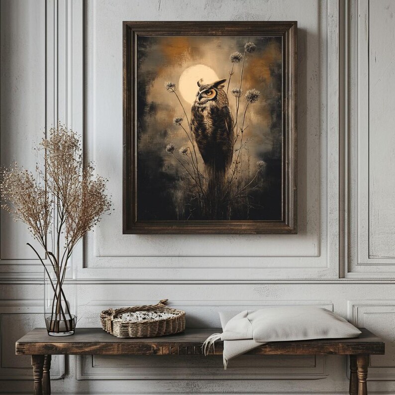 May include: A framed print of a brown and white owl perched on a branch with a full moon in the background. The owl has yellow eyes and is looking to the left. The background is a dark brown and gray color with a textured look.