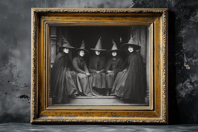 May include: A framed black and white print depicting five people in witch hats and cloaks. The image is set in a gold ornate frame, creating a vintage aesthetic. Ideal for Halloween or gothic-themed decor.