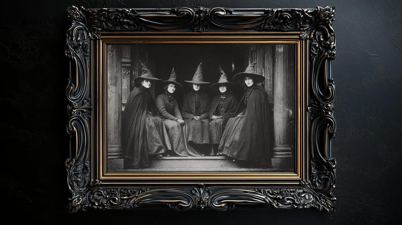 May include: A framed monochrome photograph depicting five individuals in witch hats and cloaks. The elaborate frame is black with gold detailing. The image is set against a dark backdrop, evoking a vintage, gothic atmosphere.