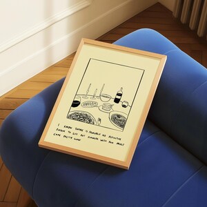May include: A framed art print featuring a black and white illustration of a dinner table setting with wine glasses, a bottle, and plates of food. The print has a light wood frame and includes the text: "I know there is probably no definitive purpose to life but dinners with you must come pretty close."