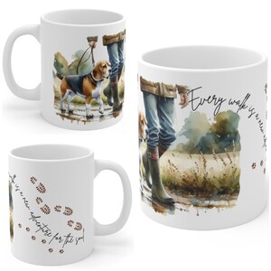 May include: White ceramic mug with a watercolour illustration of a beagle on a lead with a person. The mug has the text "Every walk is a new adventure for the soul" and paw prints.