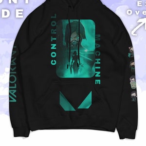 May include: Black hoodie with a green graphic of a character from the video game Valorant. The graphic says "Control Machine" and "Valorant" is written vertically on the left sleeve.