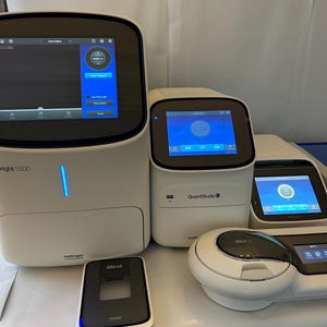 Puede incluir: Una colección de equipos de laboratorio blancos y negros, que incluyen un instrumento grande etiquetado como "Bright 1500" y dispositivos más pequeños con pantallas digitales. Los dispositivos tienen pantallas que muestran interfaces azules y blancas. La imagen incluye el dispositivo "iBind".