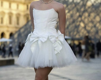 Romantic ivory corset dress with flowing tulle skirt and delicate bows accents - timeless beauty. Perfect for weddings or special occasions.