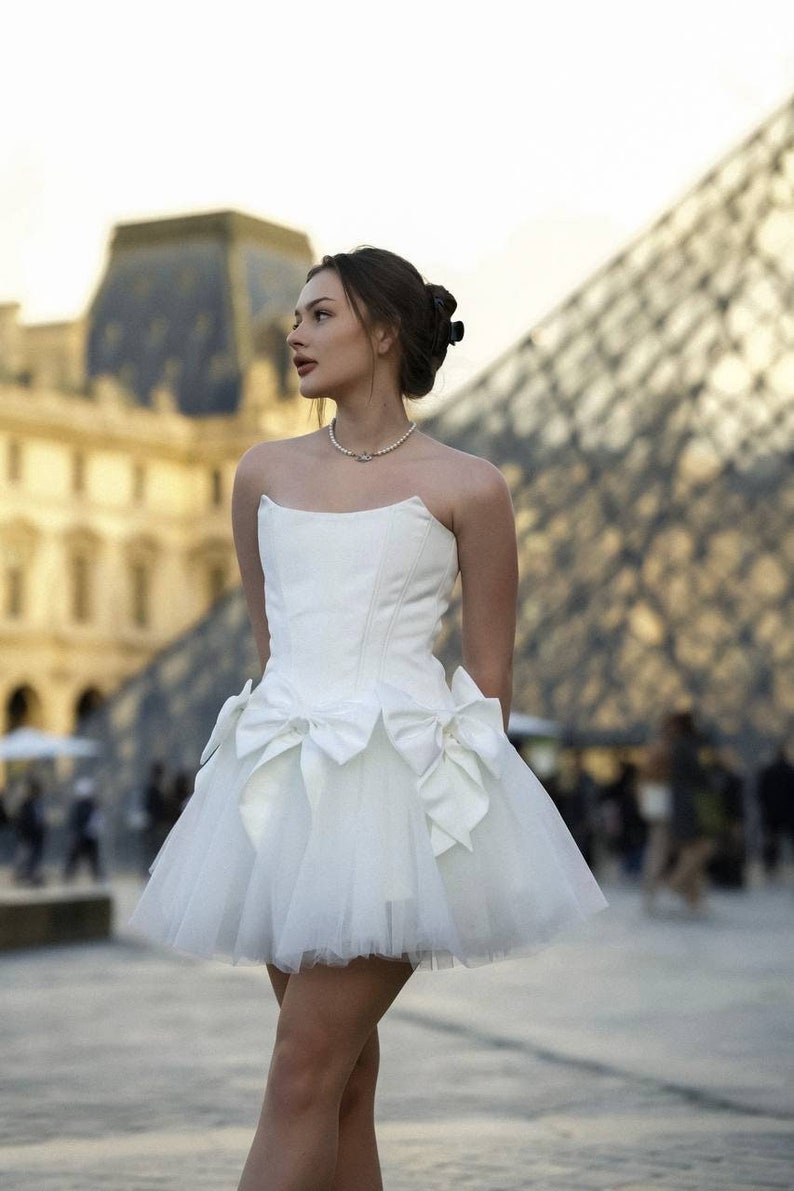 Romantic ivory corset dress with flowing tulle skirt and delicate bows accents timeless beauty. Perfect for weddings or special occasions. image 1