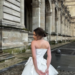 Romantic ivory corset dress with flowing tulle skirt and delicate bows accents timeless beauty. Perfect for weddings or special occasions. image 8