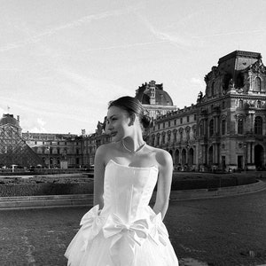 Romantic ivory corset dress with flowing tulle skirt and delicate bows accents timeless beauty. Perfect for weddings or special occasions. image 6