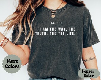 May include: Dark gray t-shirt with the text "I AM THE WAY, THE TRUTH, AND THE LIFE." from John 14:6 in white. The shirt also has the words "More Colors" and "Pepper Color" in a decorative font.