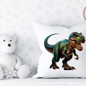 May include: White pillow with a green and brown dinosaur illustration. The dinosaur is facing right and has its mouth open. The pillow is on a white surface with a white teddy bear sitting in front of it.