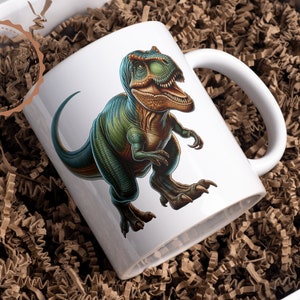 May include: White ceramic mug with a green and brown dinosaur illustration. The dinosaur is facing right and has a large mouth with sharp teeth.