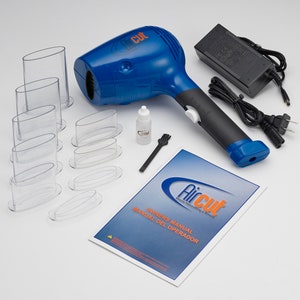 May include: A blue and black electric hair cutting tool with a clear plastic nozzle attachment. The tool is on a white surface with a manual, a bottle of oil, a brush, and several clear plastic attachments.