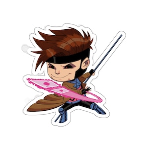 May include: A sticker featuring a cartoon illustration of Gambit from Marvel Comics. The character is depicted with brown hair, a black mask, and a brown trench coat, holding a pink energy card. The sticker has a white border.