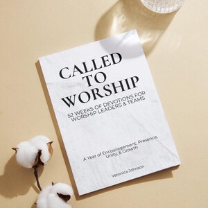 Könnte beinhalten: Ein weißes Buch mit dem Titel "CALLED TO WORSHIP" in schwarzer Schrift. Der Untertitel des Buches lautet "52 WOCHEN ANDACHTEN FÜR WORSHIP LEADERS & TEAMS". Der Name des Autors, Veronica Johnson, ist ebenfalls sichtbar. Zwei Baumwollblütenknospen befinden sich in der linken unteren Ecke.