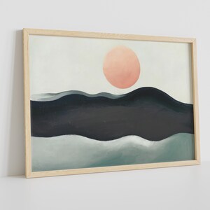 May include: A framed abstract painting with a pink circle in the upper center and a landscape of blue and green waves below.