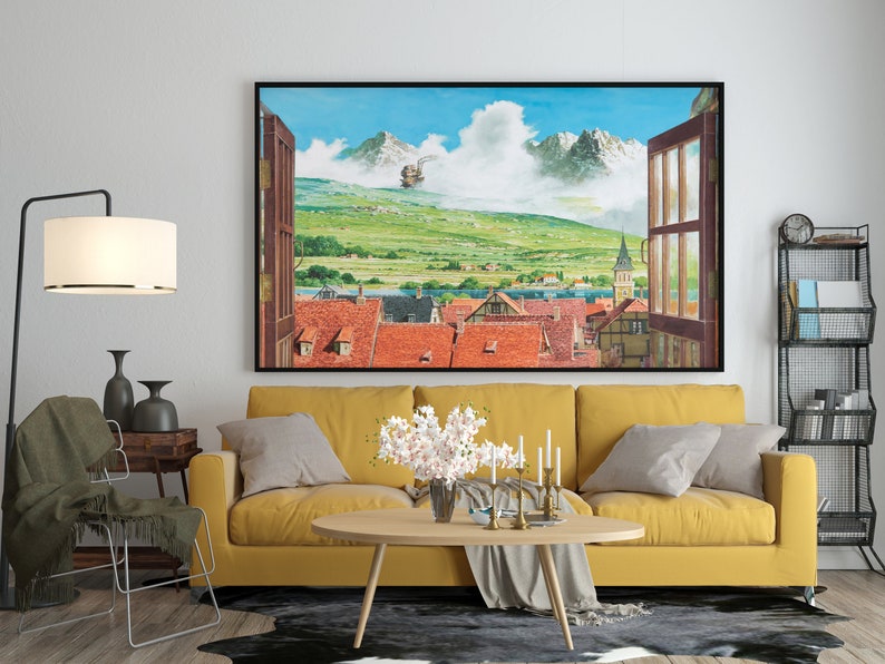 May include: A yellow sofa with two throw pillows sits in a living room with a large framed print of a town scene with a flying airship. The print is above a coffee table with a vase of white flowers and candles.