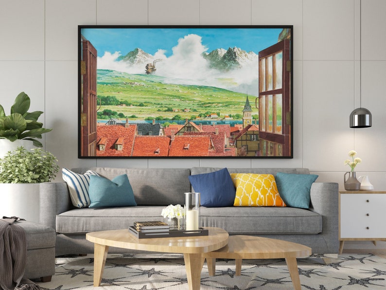 May include: A framed painting of a window view with a small town in the distance. The town is surrounded by green hills and mountains. A small airship is flying in the sky. The window is open and the frame is black.