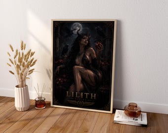 May include: A framed rectangular wall art print featuring a dark, atmospheric illustration of a horned figure with long dark hair holding a red heart. The text LILITH DESIRE is printed in gold at the bottom. The artwork is set against a moonlit background.