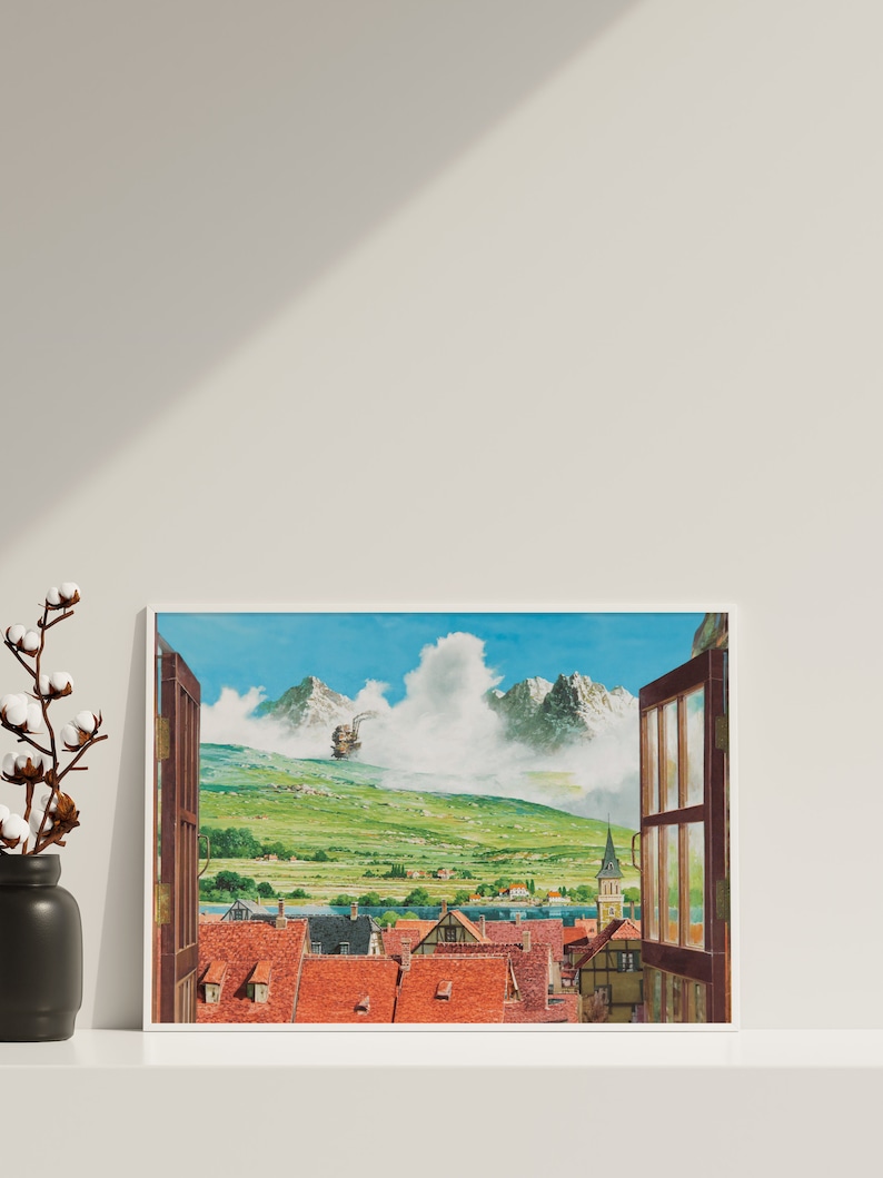 May include: A framed print of a painting depicting a small town nestled in a valley with mountains in the background. A flying machine is visible in the sky above the town. The window frame is open, revealing a view of the town.