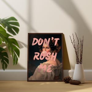 K&ouml;nnte beinhalten: Ein gerahmter Druck einer Frau mit rosa Kaugummi im Mund. Der Text "DON'T RUSH ME" ist in rosa Buchstaben auf dem Druck geschrieben.
