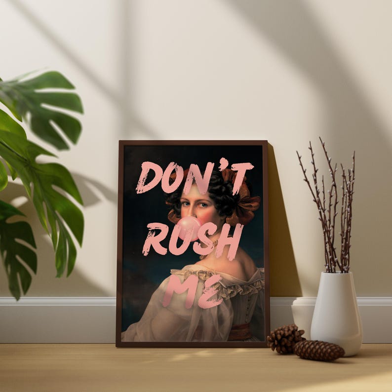 K&ouml;nnte beinhalten: Ein gerahmter Druck einer Frau mit rosa Kaugummi im Mund. Der Text "DON'T RUSH ME" ist in rosa Buchstaben auf dem Druck geschrieben.