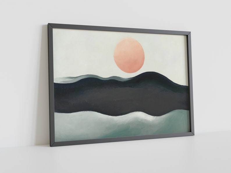 May include: A framed abstract painting with a peach-colored circle in the center, above a dark blue and green landscape. The painting is framed in a black frame.