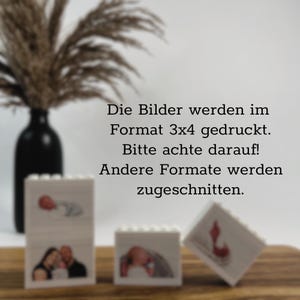 Peut inclure: Trois pr&eacute;sentoirs photo blancs en forme de blocs avec des images de personnes et d'un b&eacute;b&eacute;. Les blocs sont sur une surface en bois. Un vase noir avec des plantes s&eacute;ch&eacute;es est en arri&egrave;re-plan. Le texte dit : "Les photos sont imprim&eacute;es au format 3x4. Veuillez noter ! D'autres formats seront rogn&eacute;s."