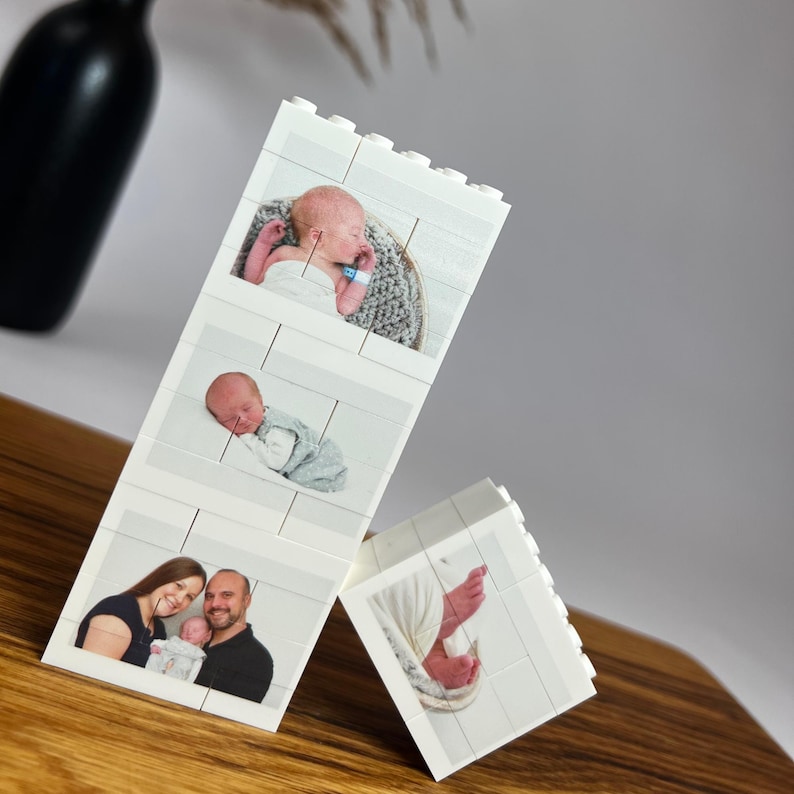 Peut inclure: Blocs blancs de style Lego affichant des photos de b&eacute;b&eacute;. Un bloc montre un b&eacute;b&eacute; dans un panier, un autre montre un b&eacute;b&eacute; endormi et un troisi&egrave;me montre une famille avec un b&eacute;b&eacute;. Un quatri&egrave;me bloc montre les pieds d'un b&eacute;b&eacute;.