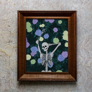 May include: A framed illustration of a skeleton with a skull smiling, standing in a garden with green leaves and purple and green flowers.