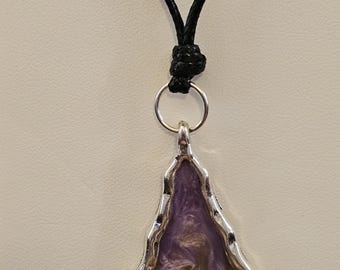 Purple and green resin in a silver bezel on a black necklace