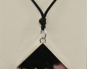 Black and purple resin in a silver bezel on a black necklace