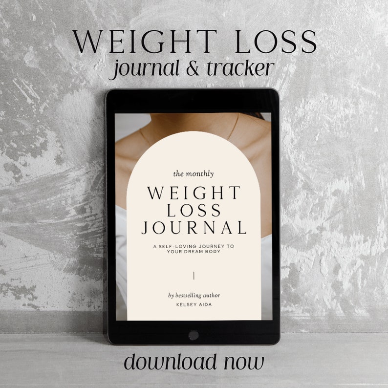May include: A digital tablet displays a journal cover with the text "WEIGHT LOSS JOURNAL" and "A SELF-LOVING JOURNEY TO YOUR DREAM BODY." The tablet is set against a textured gray background, with the words "WEIGHT LOSS journal & tracker" and "download now" also visible.