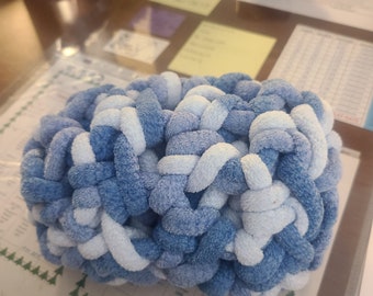 May include: Blue and white crocheted brain-shaped stress ball. The ball is made of soft, fluffy yarn and is designed to be squeezed to relieve stress.