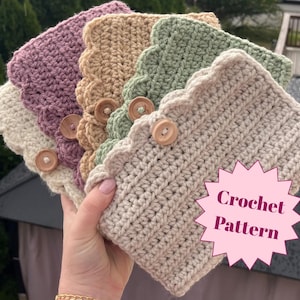 May include: A selection of crochet headbands in cream, lavender, tan, green, and beige. Each headband has a scalloped edge and a wooden button fastening. The image includes a pink starburst with the words "Crochet Pattern".