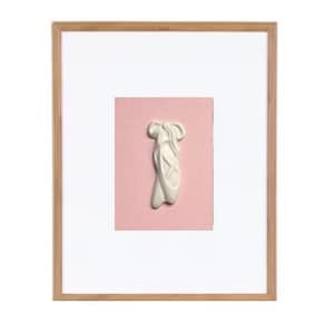 May include: A white ceramic ballerina shoe sculpture on a pink background. The shoe is in a pointe position, with the toes pointed upwards.