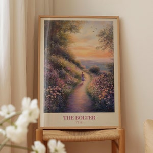 May include: A framed print of a painting showing a woman walking along a path in a field of flowers. The sky is a vibrant orange and pink, with the sun setting in the distance. The text "THE BOLTER" and "TTPD" is printed at the bottom of the print.