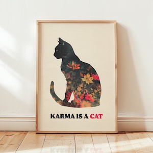 May include: A black cat silhouette with a floral pattern overlay. The text "KARMA IS A CAT" is printed below the cat.