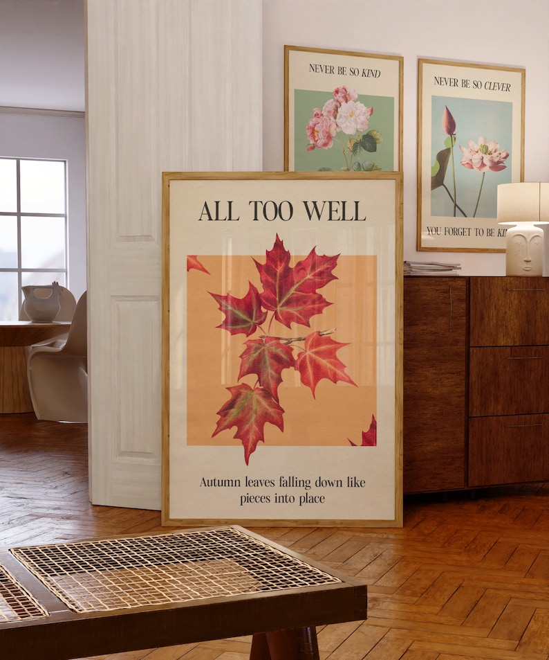 May include: A framed print with the text "ALL TOO WELL" and a quote about autumn leaves falling down like pieces into place. The print features a vintage illustration of red maple leaves on a peach background.