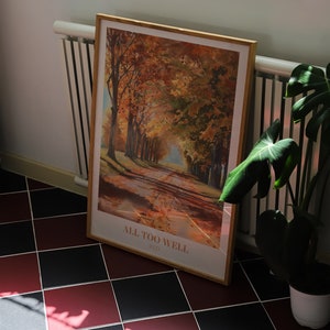 May include: A framed print of a painting depicting a road lined with trees in autumn colors. The print is titled "All Too Well (Red)".