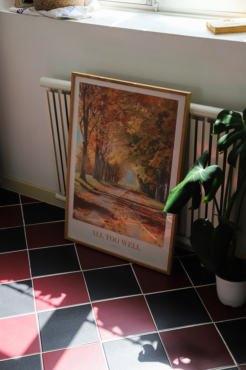 May include: A framed print of a painting depicting a road lined with trees in autumn colors. The print is titled "All Too Well (Red)".