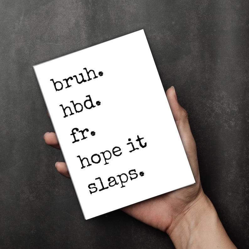 Puede incluir: Una tarjeta blanca con texto negro que dice "bruh. hbd. fr. hope it slaps." La tarjeta se sostiene en una mano sobre un fondo gris oscuro. El texto est&aacute; en una fuente de estilo m&aacute;quina de escribir.