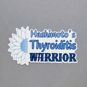 May include: A rectangular sticker featuring a light blue sunflower graphic on the left side. The text Hashimoto's Thyroiditis WARRIOR is printed in shades of blue, with the word WARRIOR in a bold, dark blue font against a white background.