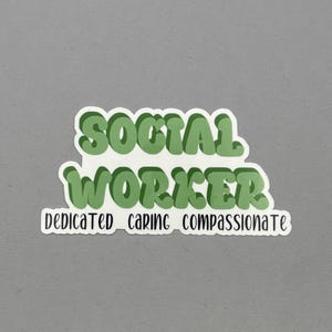May include: A sticker with the words "SOCIAL WORKER" in green bubble letters. Below, smaller text reads "DEDICATED CARING COMPASSIONATE". The sticker has a white border and is set against a gray background.
