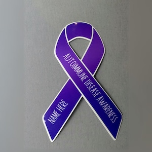 May include: Purple awareness ribbon with the text "Autoimmune Disease Awareness" and "Name Here" printed on it.
