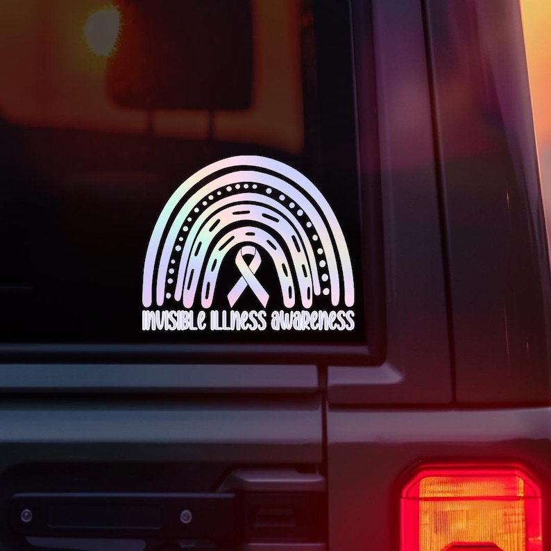 May include: White vinyl decal featuring a rainbow design with a ribbon in the center. The text "Invisible Illness Awareness" is below the rainbow. The decal is displayed on a vehicle window.