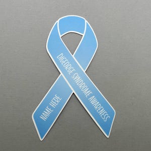May include: Light blue ribbon with the text "DiGeorge Syndrome Awareness" and "Name Here" printed on it.