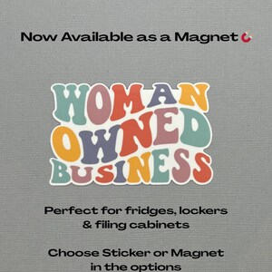 May include: A colorful sticker or magnet with the words "WOMAN OWNED BUSINESS" in a retro font. The text is in shades of blue, orange, purple, and pink. The background is a light gray.