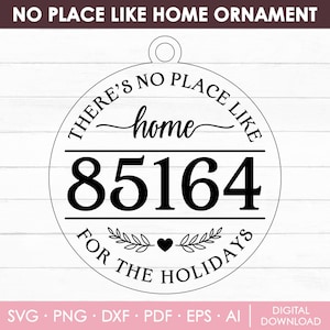 Puede incluir: Adorno redondo en blanco y negro con el texto "THERE'S NO PLACE LIKE HOME" en la parte superior. La palabra "home" está en cursiva, con los números "85164" debajo. La parte inferior dice "FOR THE HOLIDAYS".