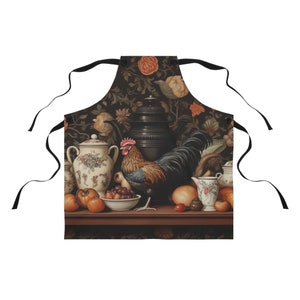 Könnte beinhalten: Eine schwarze Schürze mit einem Vintage-Stillleben-Design mit einem Hahn, Obst und antiker Keramik. Das Design ist vor einem dunklen floralen Hintergrund angeordnet.